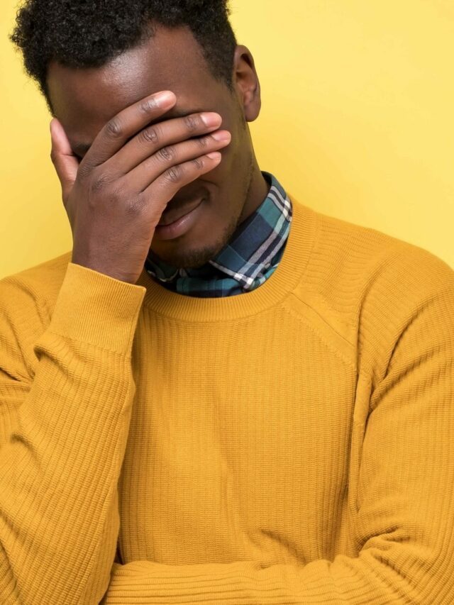 Young african man is hiding his face in the palms of his hands