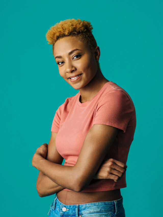 Portrait of a smiling young female with cool short hair and arms crossed