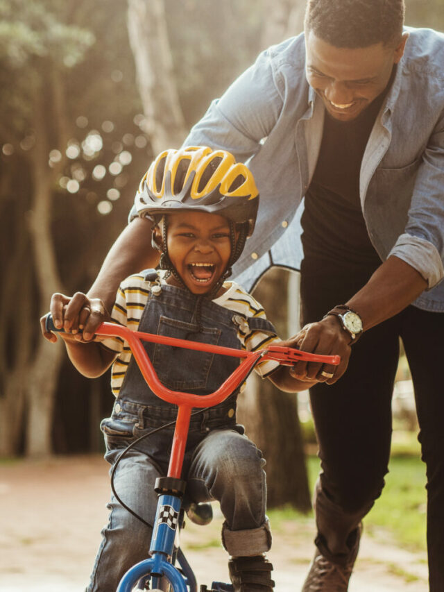 Father teaching his son cycling at park