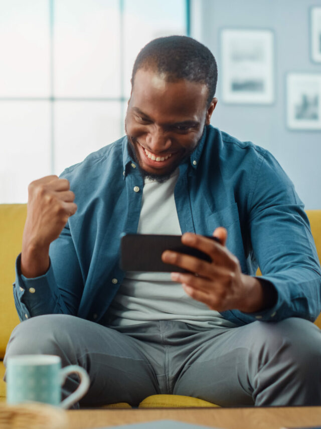 Happy Black African American Man Playing Video Game on Smartphon