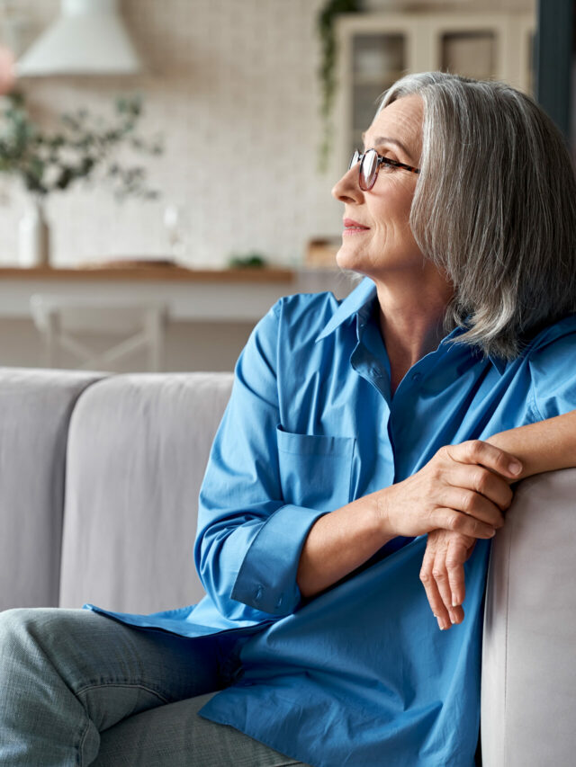 Stories Calm relaxed mature older woman relaxing sitting on couch at home.